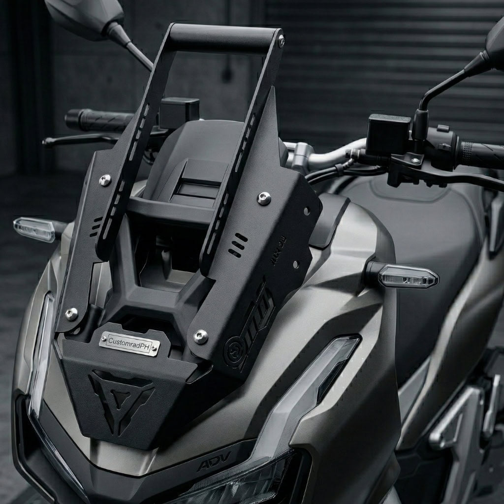 Black powder-coated CNC steel Honda ADV 160 Face Enhancer by CustomradPH installed on the front fairing of a Honda ADV 160. The plug-and-play accessory features a distinct triangular cutout, riveted metal badge, and slotted brackets, seamlessly complementing the scooter's existing angular lines to create an aggressive, structured profile.