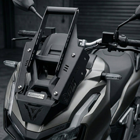 Black powder-coated CNC steel Honda ADV 160 Face Enhancer by CustomradPH, featuring a distinct triangular front cutout, riveted metal badge, and slotted side brackets designed for an aggressive front fairing styling upgrade.